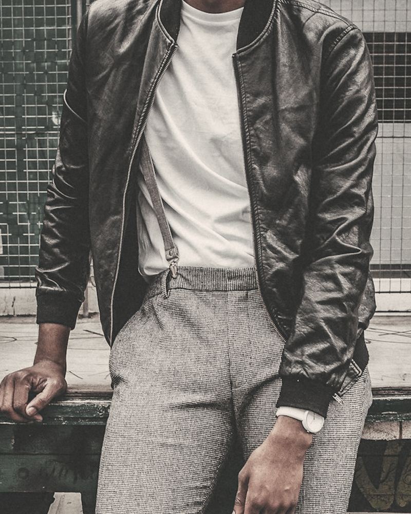 Black leather bomber jacket with ribbed collar and cuffs, worn over a white tee