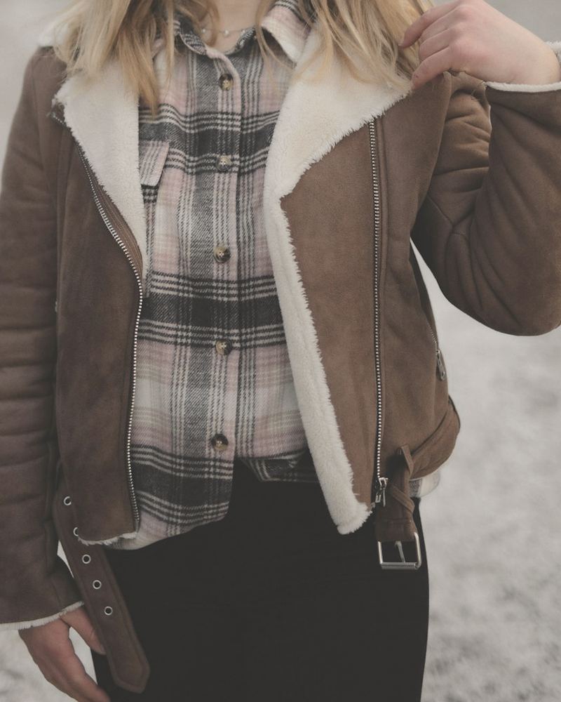Tobacco suede shearling jacket with a cream fleece collar, worn over a plaid shirt