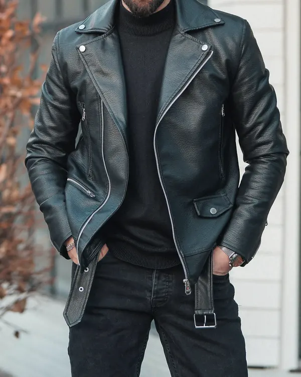 Black belted leather biker jacket with silver zips, worn open over a black polo neck