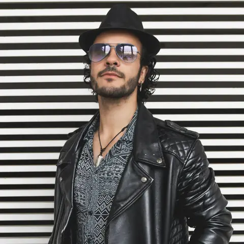 Customer wearing a black quilted biker jacket and a fedora