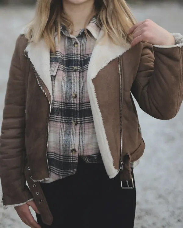Brown suede shearling jacket with a cream fleece collar and a belted hem